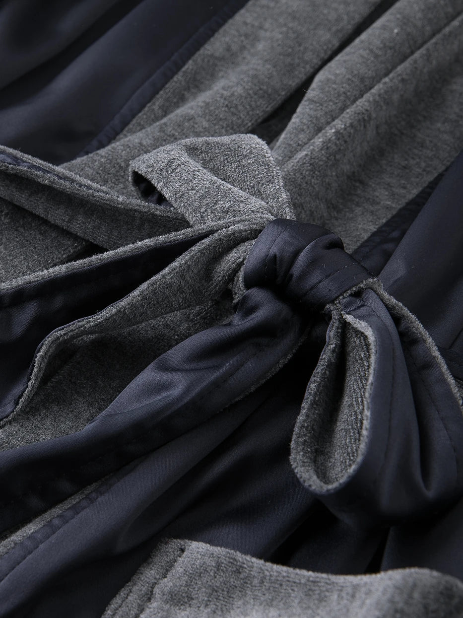 Macro close-up of waist tie joint craft of HERA double-layer bathrobe, contrast composite structure of dark blue polyester outer and grey cotton inner, neat stitching, firmly bonded double layers resistant to delamination and loose threads