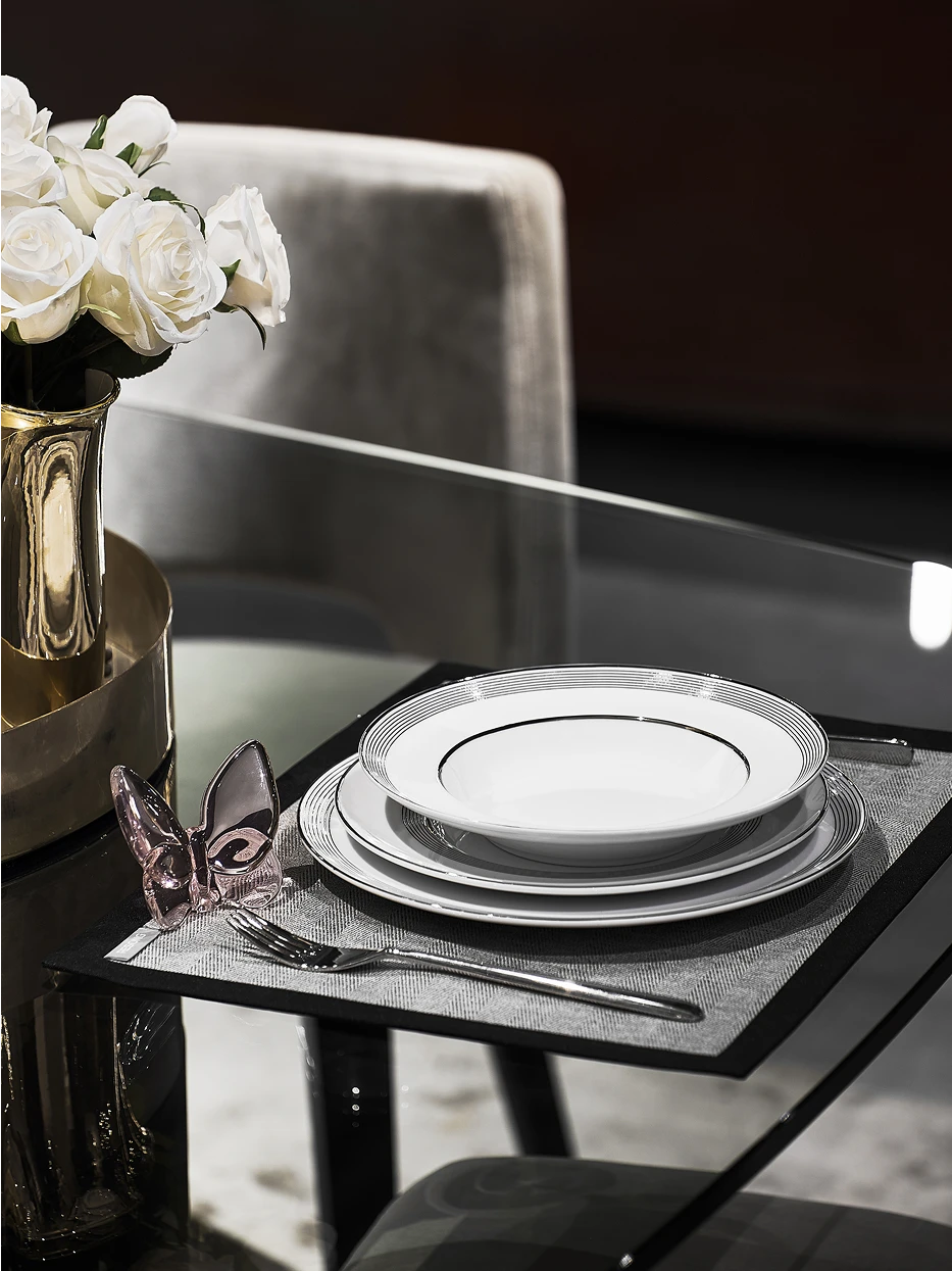 Minimalist home living room decor shot of ERYA black silver plate set on glass round coffee table, paired with rose gold butterfly ornament, white rose silver vase and fabric leisure armchair