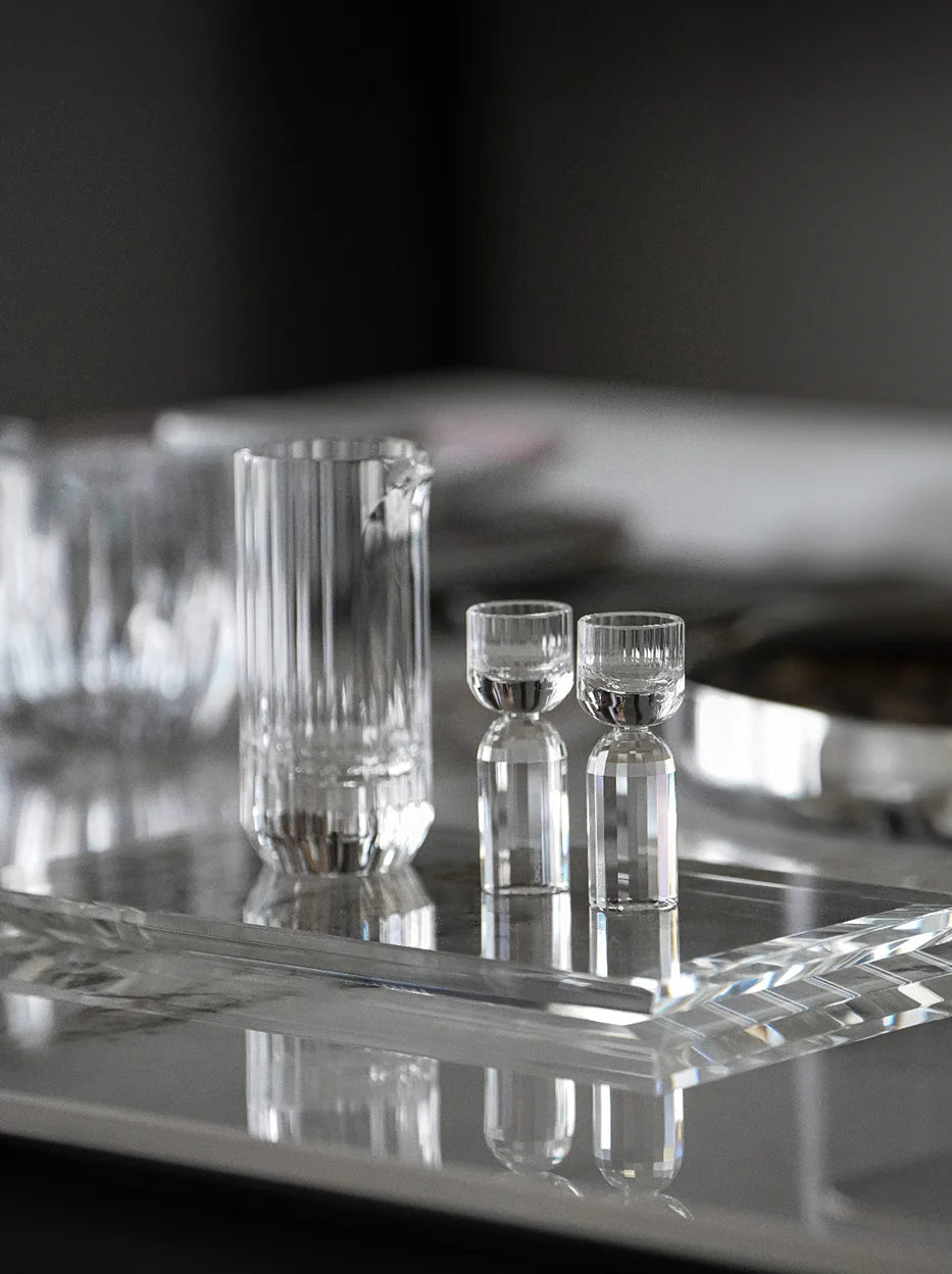 Minimal dark studio interior shot of full HAOYING crystal baijiu set laid on thick transparent crystal tray, reflective tabletop showing complete mirror reflection