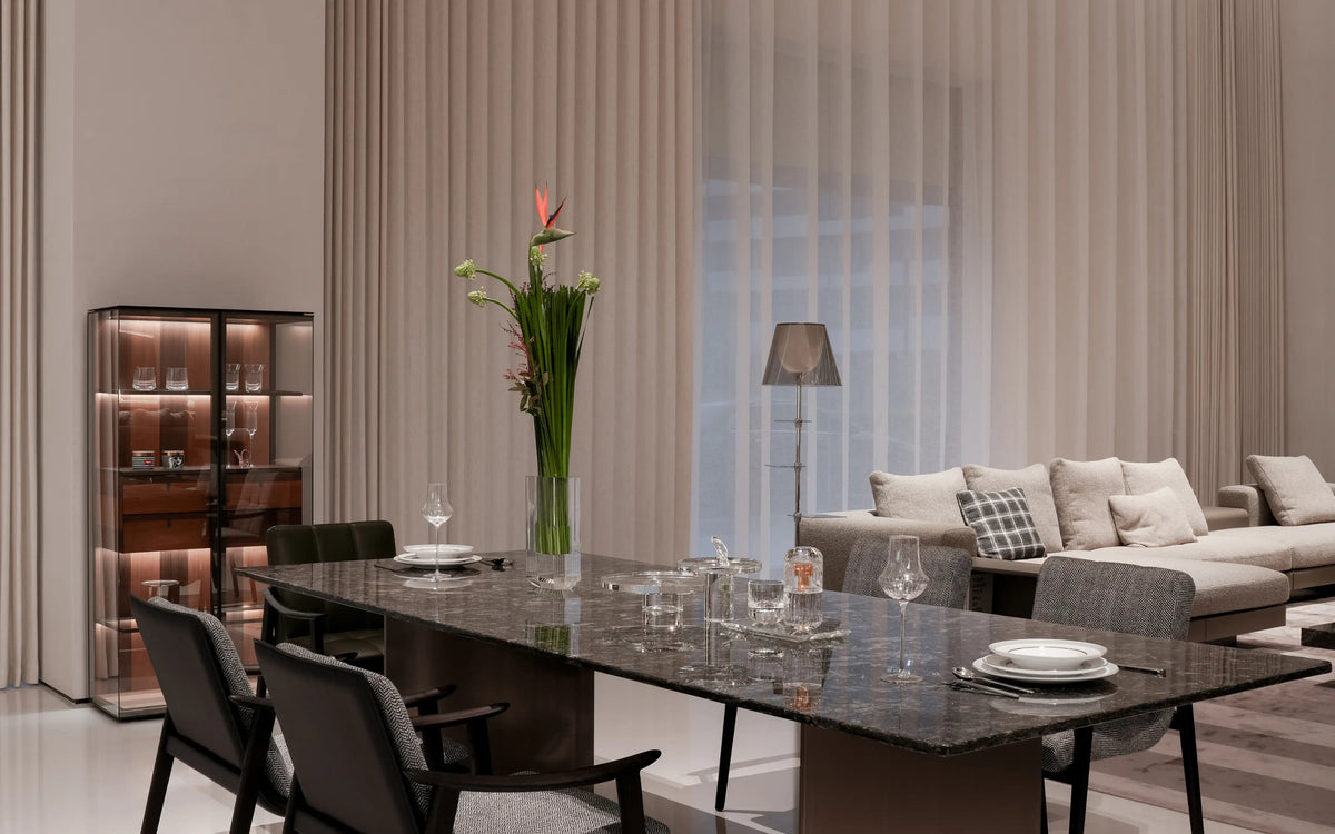 RESONG Home modern luxury open-concept dining and living room panorama, dark marble dining table with side glass display cabinet, curated with TRIUMPH Whiskey Collection, XUYU hand-carved crystal glassware, XUYU high-clarity cubic vase with florals, ERYA high-temperature porcelain steak dinner set and STARLIGHT crystal fruit plates. Minimalist high-end interior, ideal for villa dining space, luxury model home soft furnishing, residential home decor inspiration