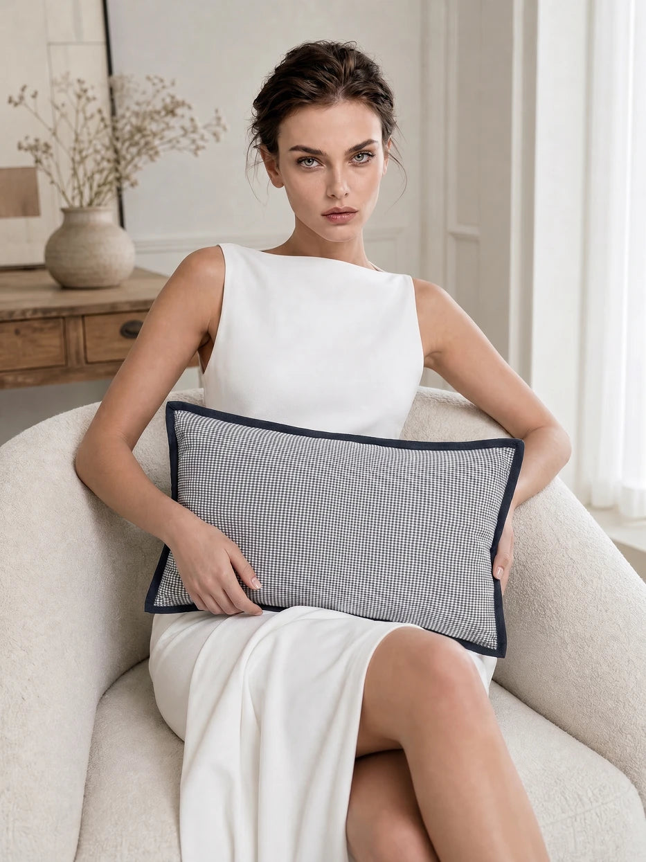 Pure white background half portrait shot of model holding LUODI retro check cashmere lumbar pillow, displays soft waist-fitting support effect of goose down filling, highlights plump comfortable touch and retro fabric texture, minimalist high-end home textile display for daily waist rest scene