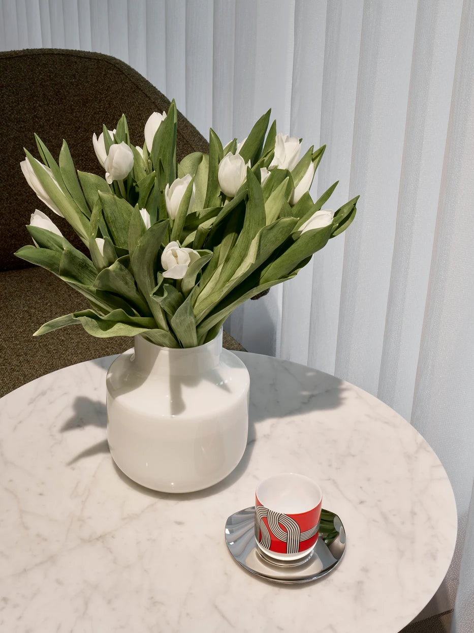 Cream-style furnishing shot of minimalist vase B full of white tulips on white marble round side table beside sheer curtain