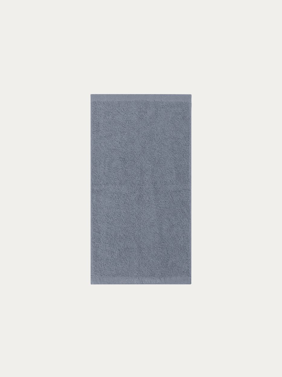fficial flat lay product shot of R Collection gray cotton bath towel on pure off-white background, wide 1400×700mm size, 640g heavy dense cotton terry loop, matching tone embroidered RESONG TOWELS logo on hem, neutral style full-body water-absorbent towel for hotel & household