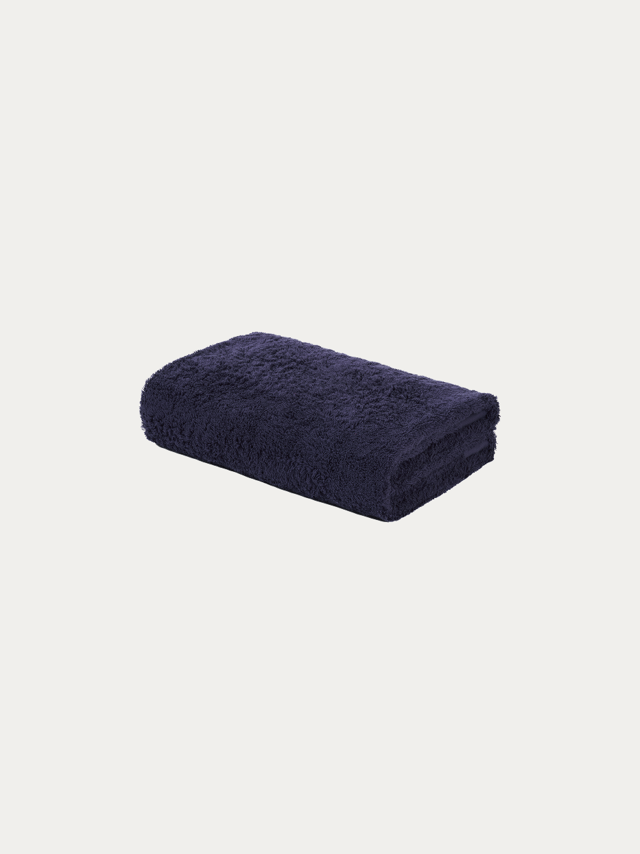 Official flat lay product shot of R Collection navy blue cotton bath towel on pure off-white background, full-body wrap size 1400×700mm, 640g heavyweight thick cotton terry loop, matching tone subtle embroidered RESONG TOWELS logo on hem, stain-resistant absorbent large towel for business hotel & men household gift set