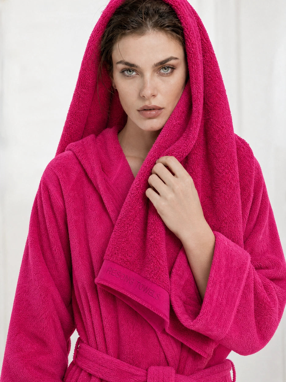 Half-body detail scene shot of model wrapping hair with R Collection rose red cotton bath towel under plain minimalist background, clearly displays embroidered RESONG TOWELS detail on hem, shows multi-scene usage for hair drying & body wiping after shower, intuitively presents fluffy thick texture of heavyweight terry