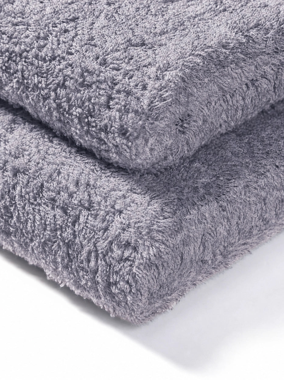 Extreme macro texture close-up of 100% cotton terry of R Collection grey face towel, full three-dimensional loop terry grain, clearly shows thick 200g heavyweight texture, soft skin-friendly cotton and fast water absorption, dense weave resistant to lint shedding and fading after repeated washes