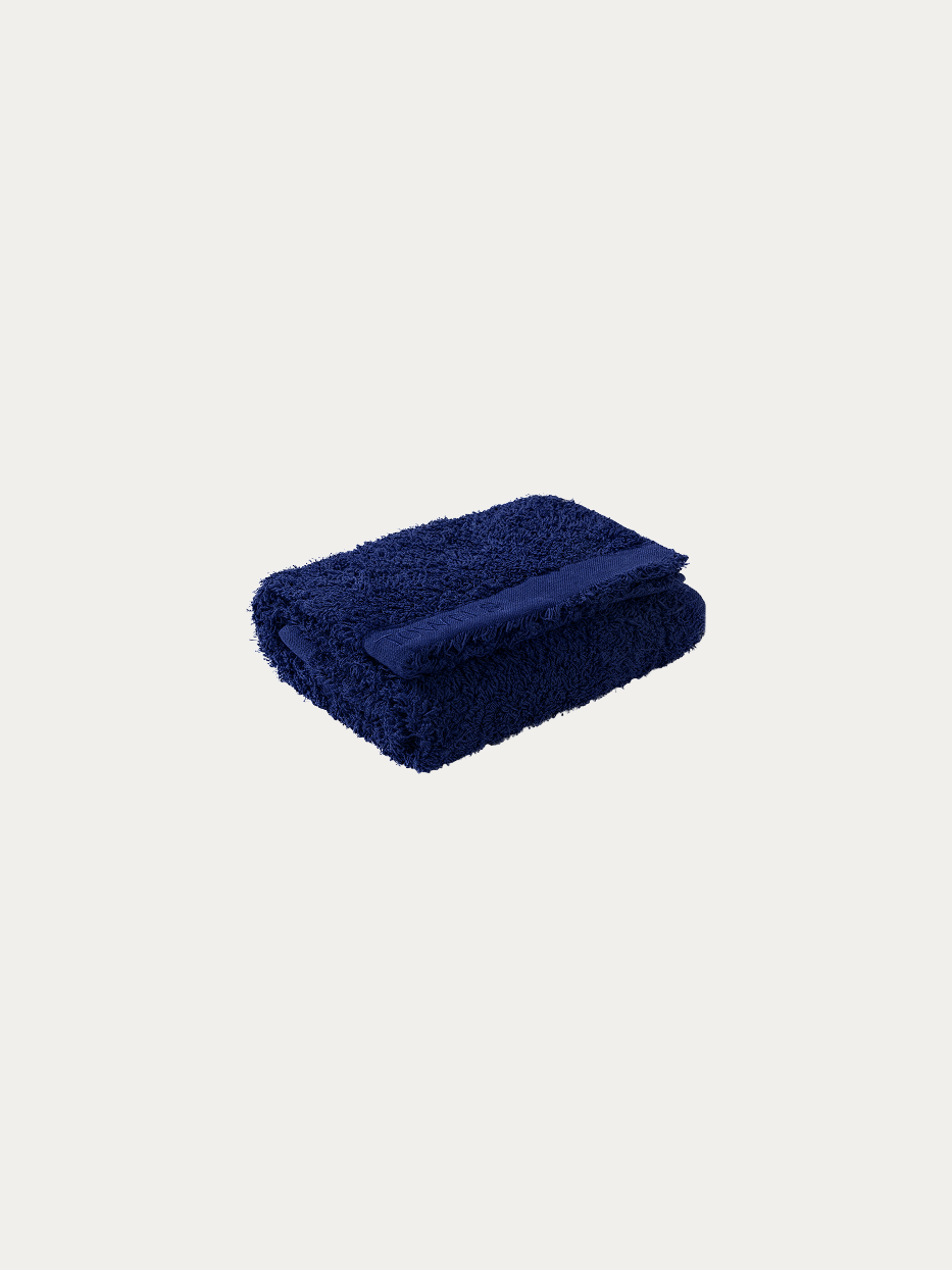 Official folded product shot of R Collection navy blue cotton face towel on pure off-white background, oversized 750×410mm, 200g heavyweight thick terry, woven band embroidered with TOWELS logo, stain-resistant water-absorbent facial towel for business hotel & men household gift box matching