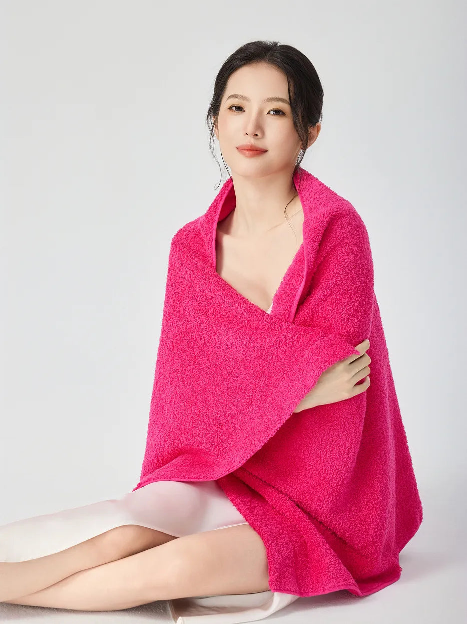 Woman wrapped in RESONG rose red cotton terry cloth bath towel, bright pink luxury absorbent bath towel on model, white studio background