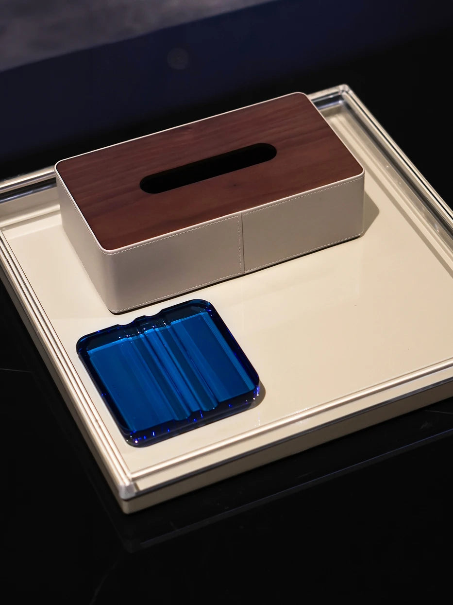 Luxury club layout shot of deep blue crystal cigar holder matched with leather & wood tissue box on large metal display tray