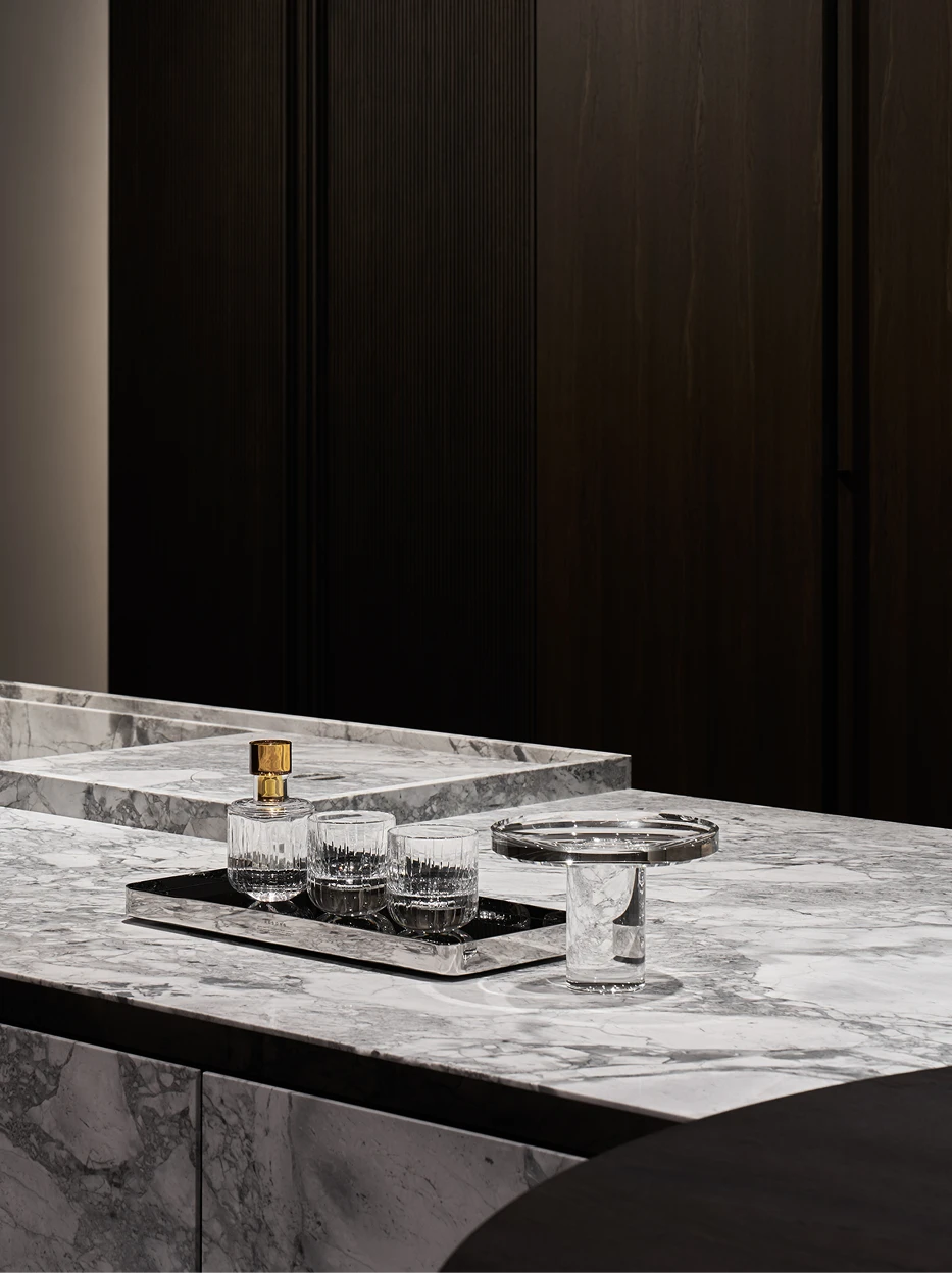 Minimal high-end furnishing shot of staggered SHIJI L & M fruit plates on light wood surface against solid dark backdrop