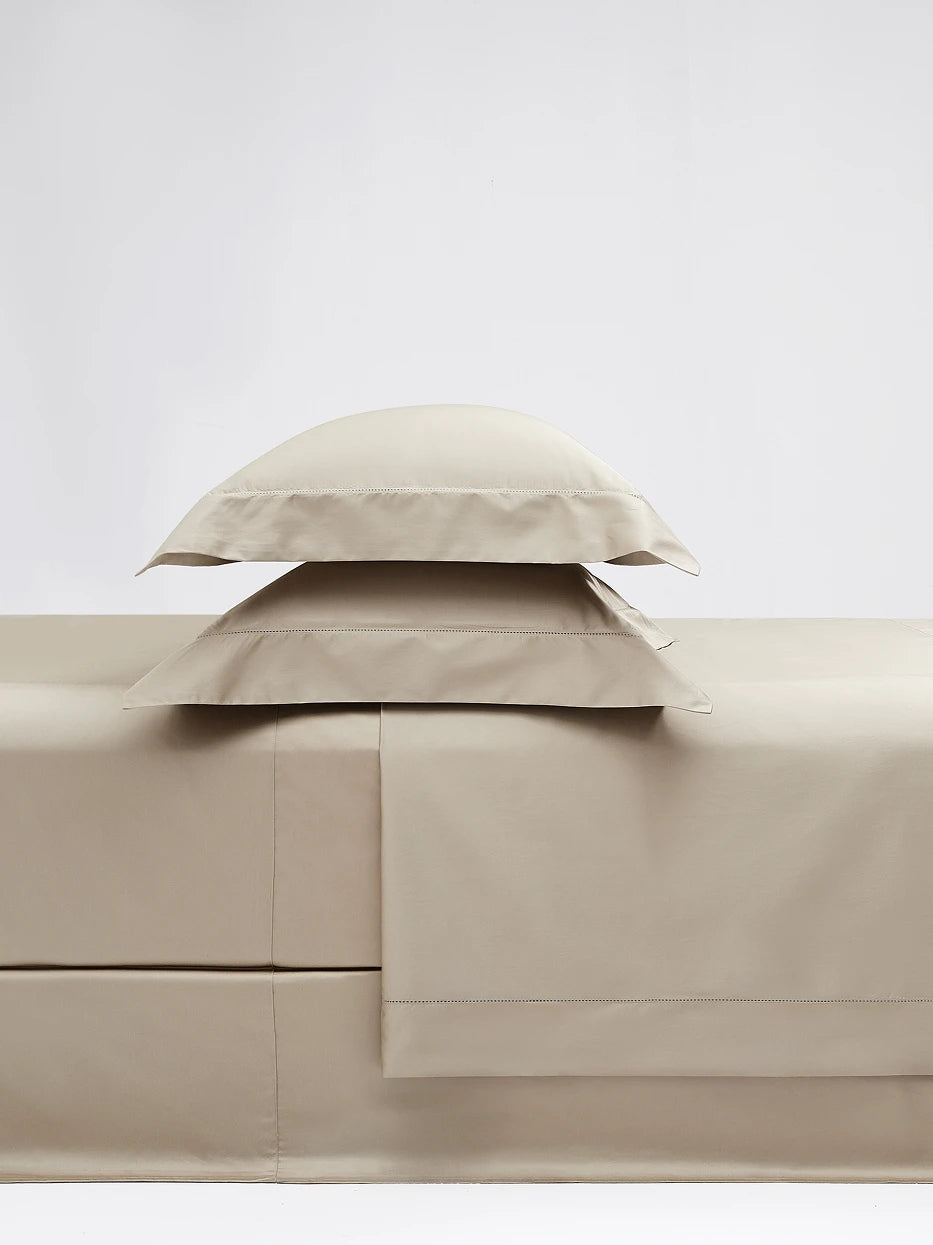 Close-up furnishing shot of full SHUMIAN champagne gold bedding pillow set showing silky Awat cotton fabric & delicate eyelet embroidery edge