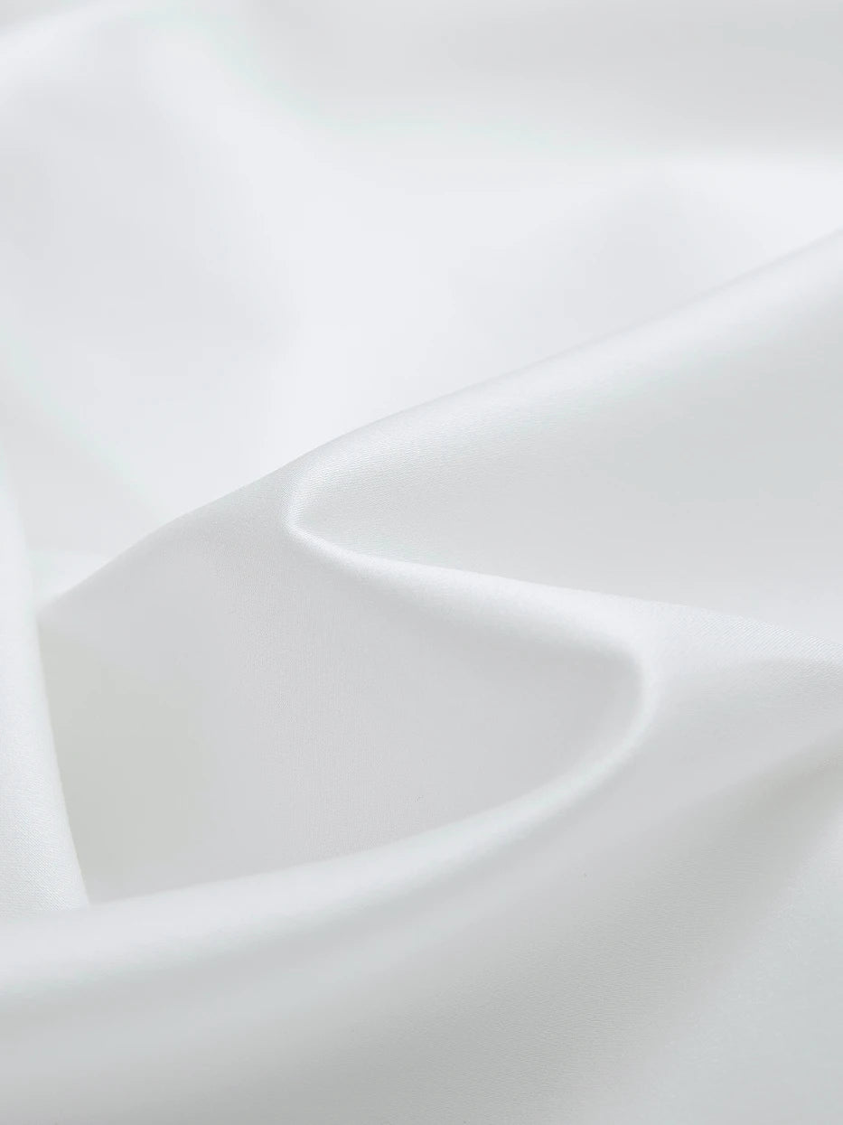 Soft natural light close-up shot of SHUMIAN pearl white silky cotton fabric, smooth tight 480TC weaving with matte soft luster
