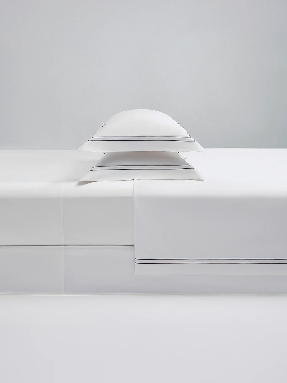 Close-up furnishing shot of full SHUMIAN pearl white XL bedding pillow set showing silky Awat cotton fabric & delicate eyelet embroidery edge