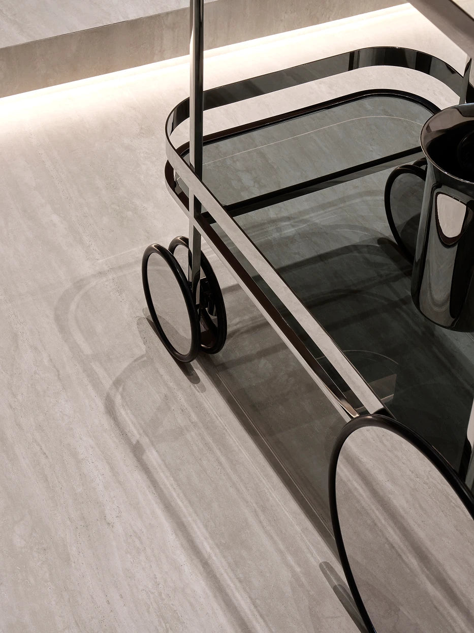 Texture close-up shot of cart frame, gray glass tray and asymmetric mirror casters under soft single side light