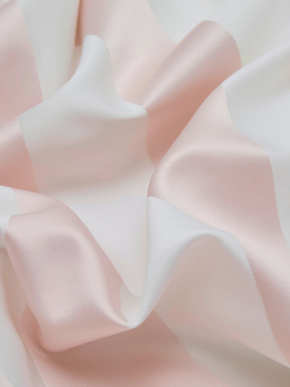 Soft light close-up shot of XUGUANG pink cotton fabric, showing three-dimensional wide yarn-dyed pink & white stripes, tight 600TC weaving with matte silky luster
