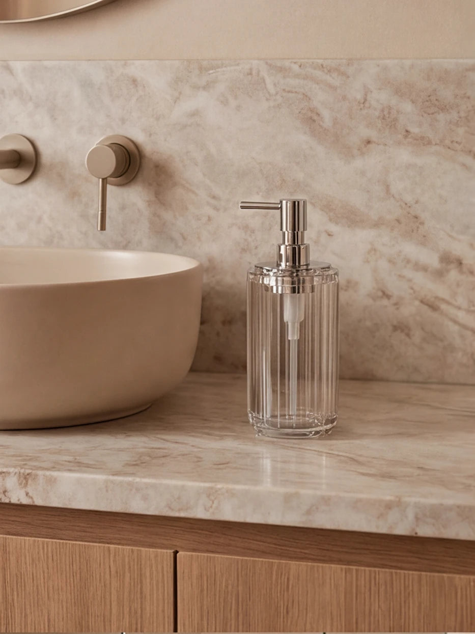 Cream wood bathroom furnishing shot of XUYU crystal lotion bottle beside matte light wood wash basin