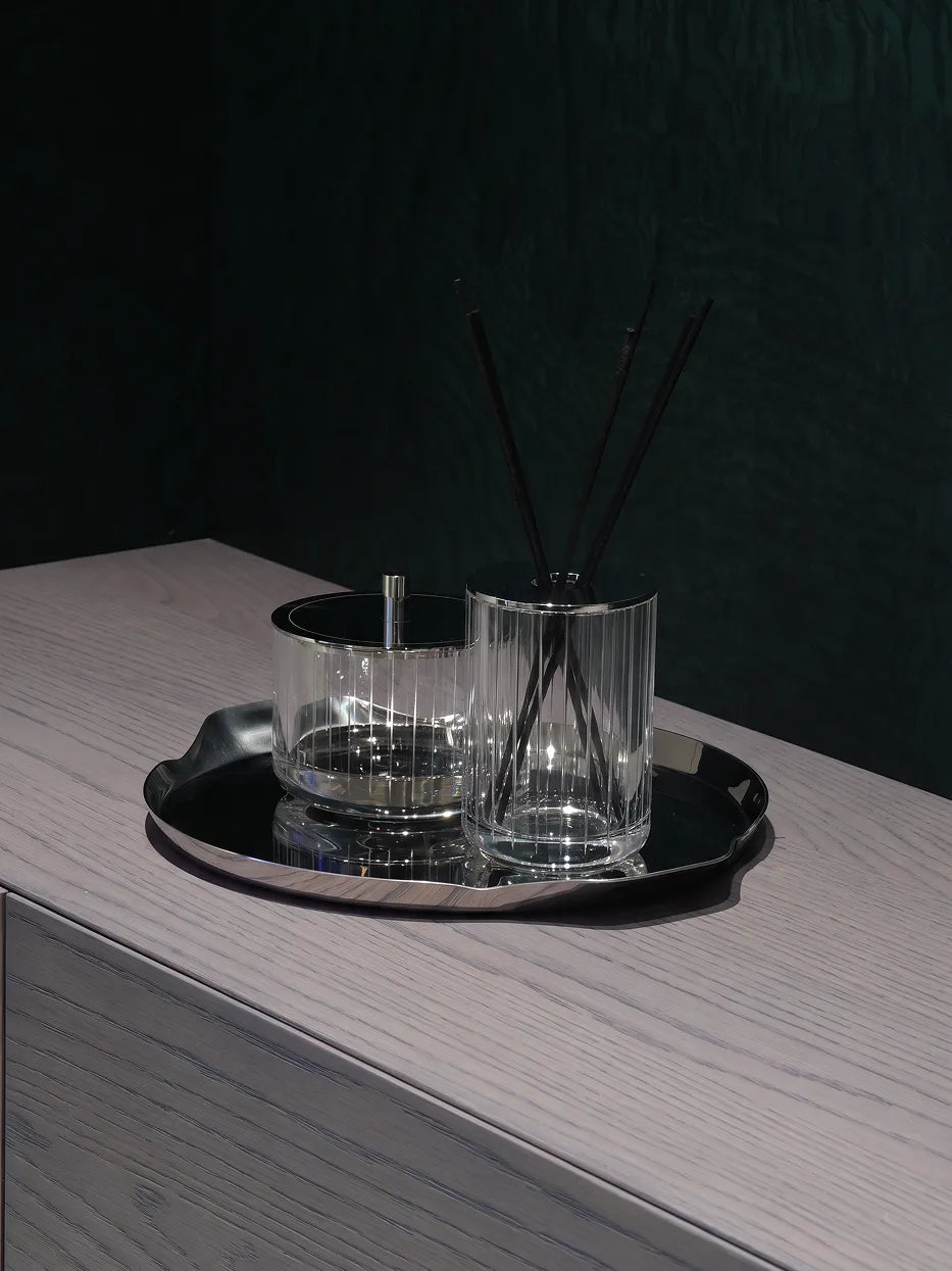 Soft minimalist vanity furnishing shot of XUYU crystal set on mirror metal tray over light wood cabinet