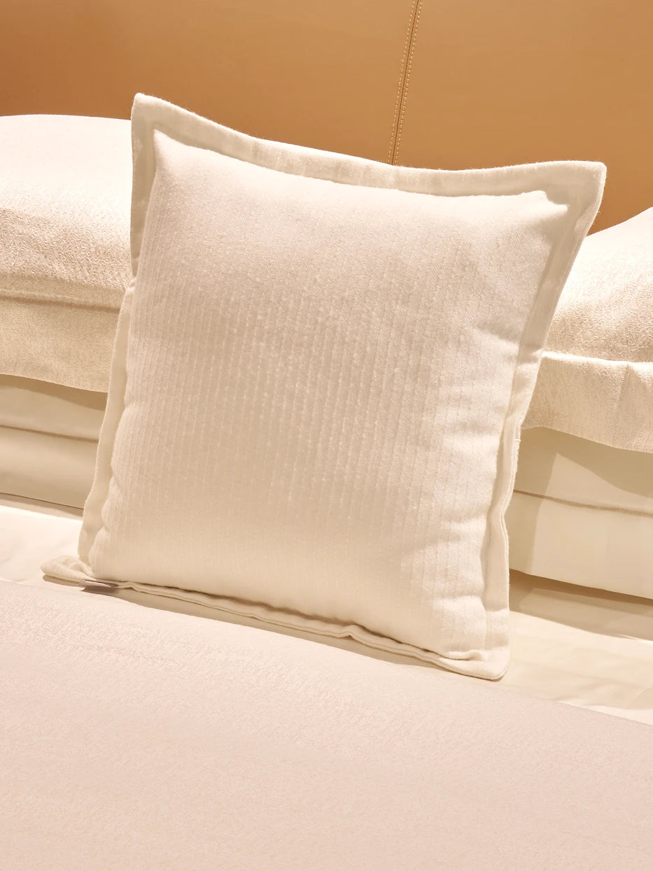 Bedside close-up texture shot of BERLIN wool blend white stripe cushion, showing dense vertical ribbed stripe texture and seamless neat finished edge detail, visible soft wool touch and silky drape of viscose fiber, displays premium multi-fabric knit craft and plump goose feather filling tactile texture for home textile product display