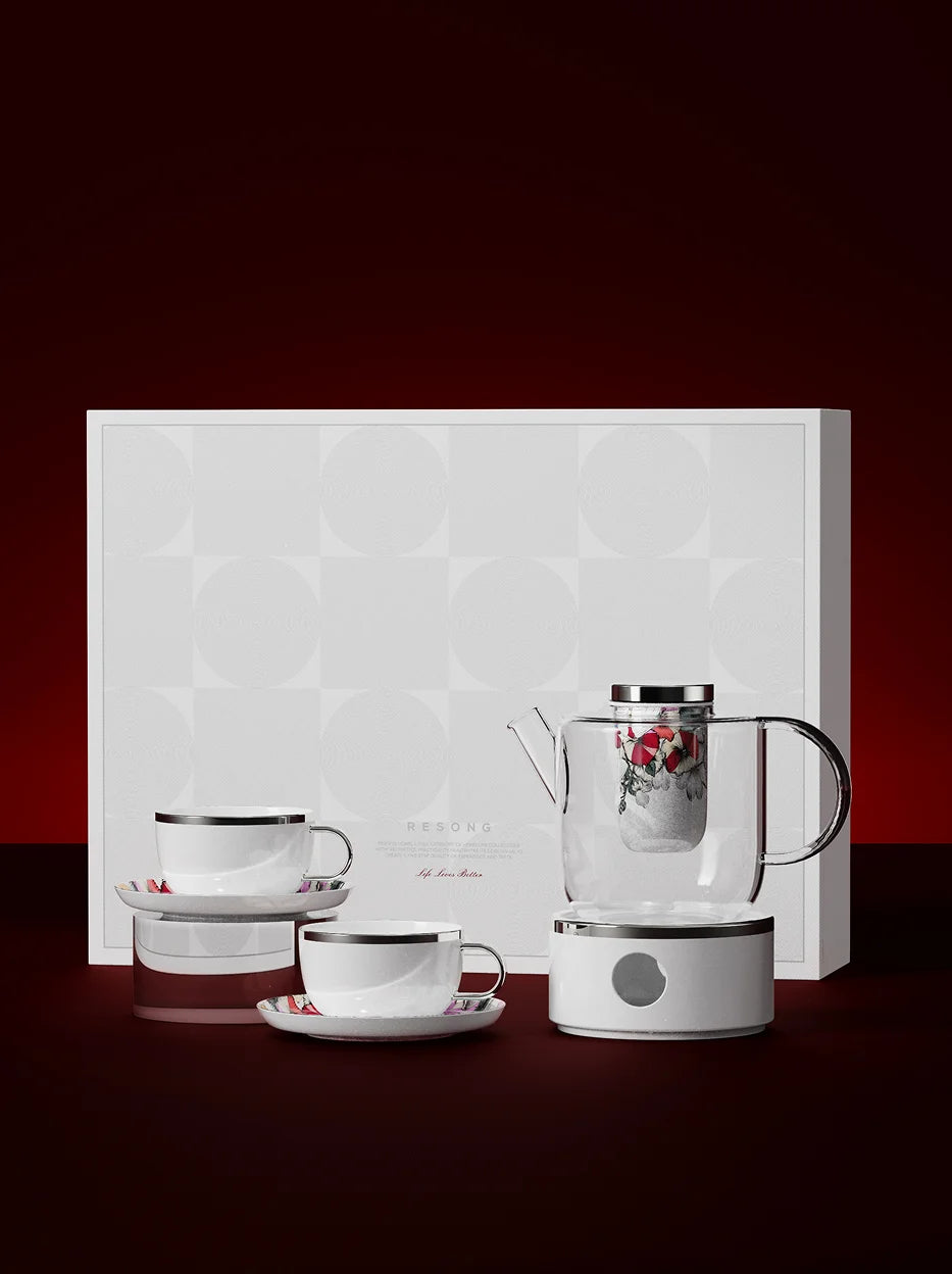 Official full gift set shot of RESONG BUTTERFLY WHISPER ceramic cup & saucer tea set on deep red background, matching clear glass health teapot with heating base, complete premium tea gift box for home tea time & holiday gifting