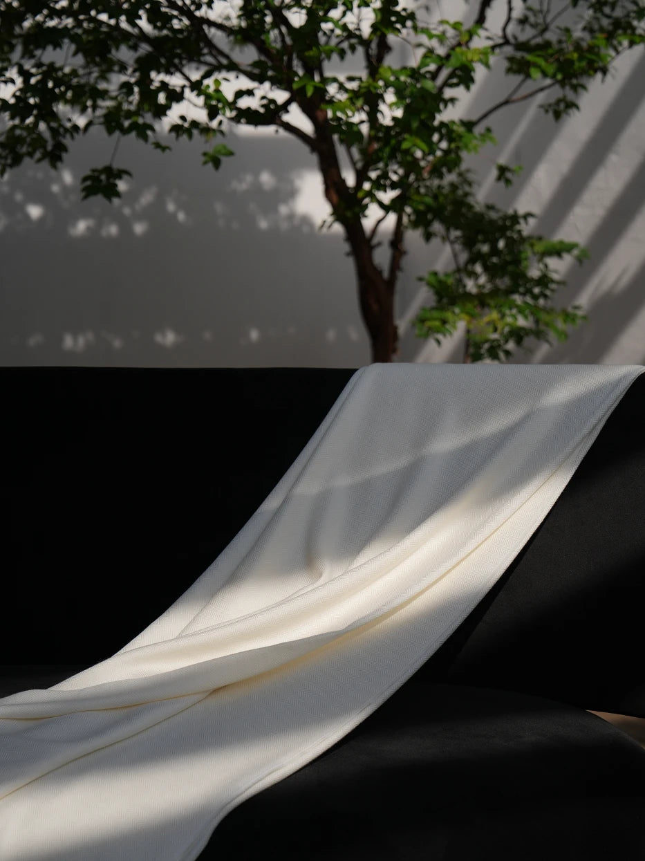 Extreme drape texture shot of CHENZHI linen TENCEL wool blend throw blanket, showing delicate herringbone woven texture and loose handmade tassel fringe detail, visible silky luster of TENCEL™, breathable linen weave and soft wool mixed touch, neatly cut natural fringed edges, displays premium multi-fabric craft and smooth drape tactile texture for home textile product display