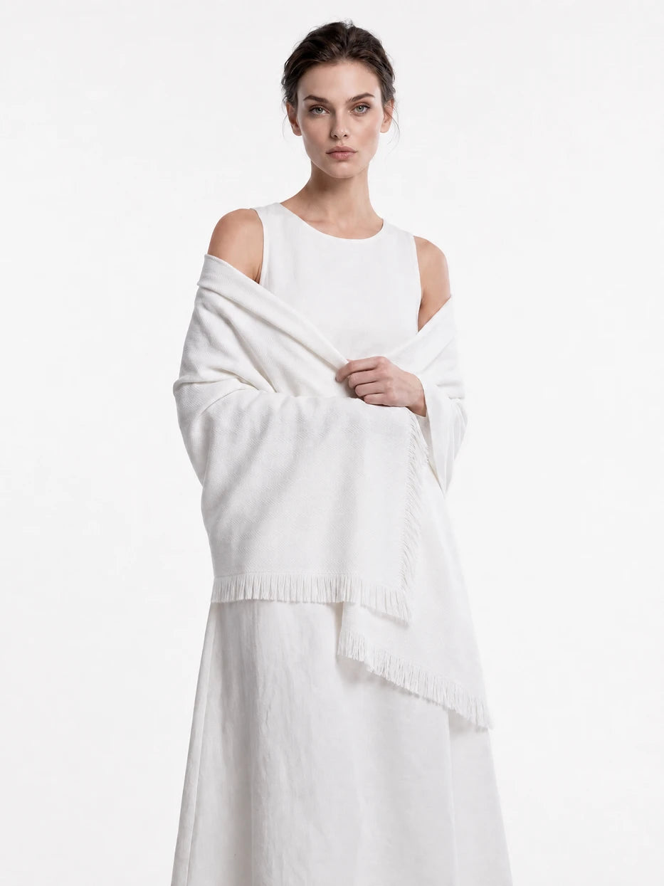 Pure white background half portrait shot of model wrapped with CHENZHI white herringbone wool blanket, demonstrates multi-scene usage as wearable shawl, office nap cover, outdoor beach wrap, lightweight silky breathable linen wool blend fabric suitable for all seasons, minimalist wearable home textile for dai