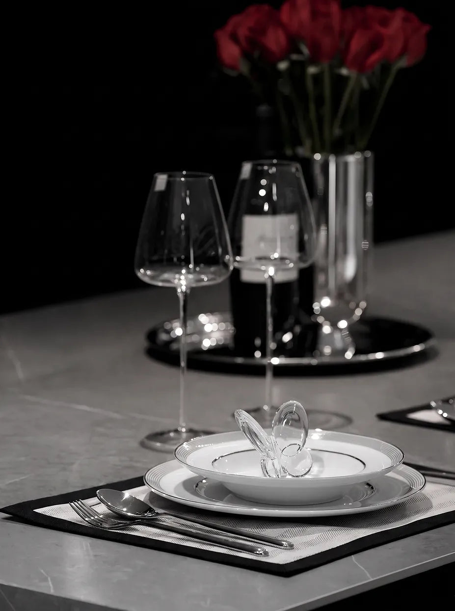 Monochrome minimalist dining furnishing shot of clear crystal butterfly in double-layer gold-rim ceramic bowl on grey stone dining table