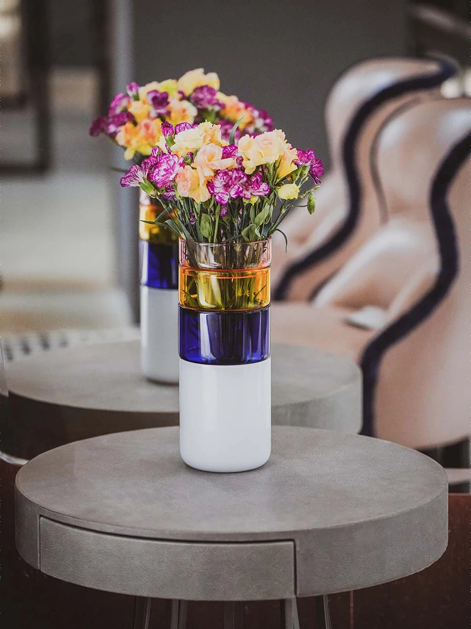Retro light-living furnishing shot of Color Block Vase A full of mixed carnations on matte grey round side table