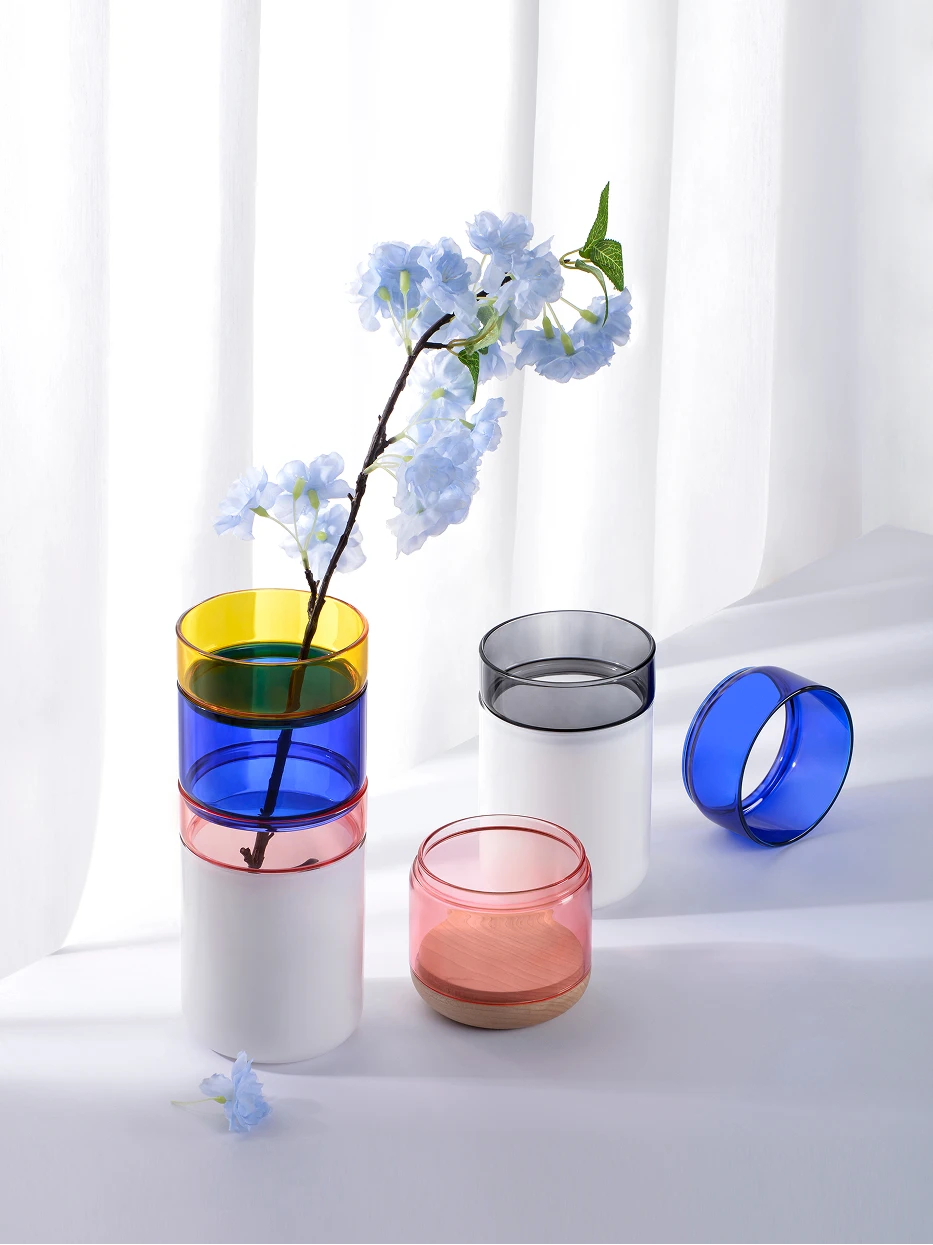 Soft minimalist display furnishing shot of disassembled Color Block Vase A with single light blue cherry blossom beside sheer white curtain