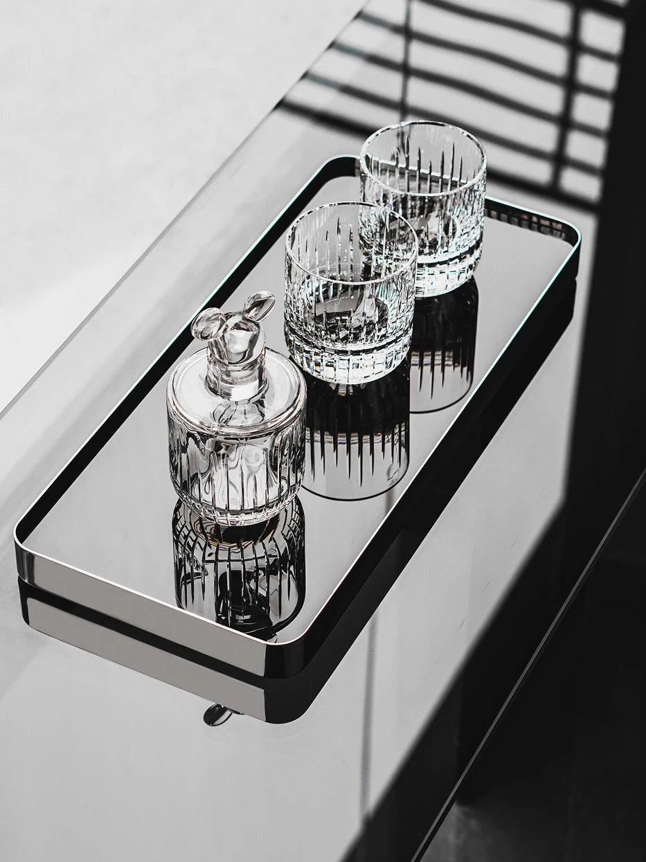 Luxury still life close-up of HD jet black M tray with vertical striped glass storage jars on glossy black countertop