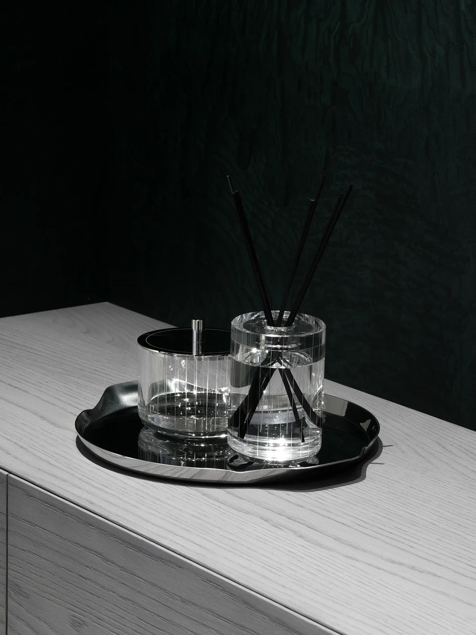 Minimal entryway layout shot of large HD L handled tray holding glass reed diffuser jars on light wood console cabinet