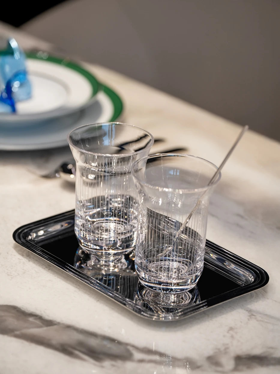 Home afternoon tea layout shot of HD small metal tray with vertical striped glass cups on marble dining table
