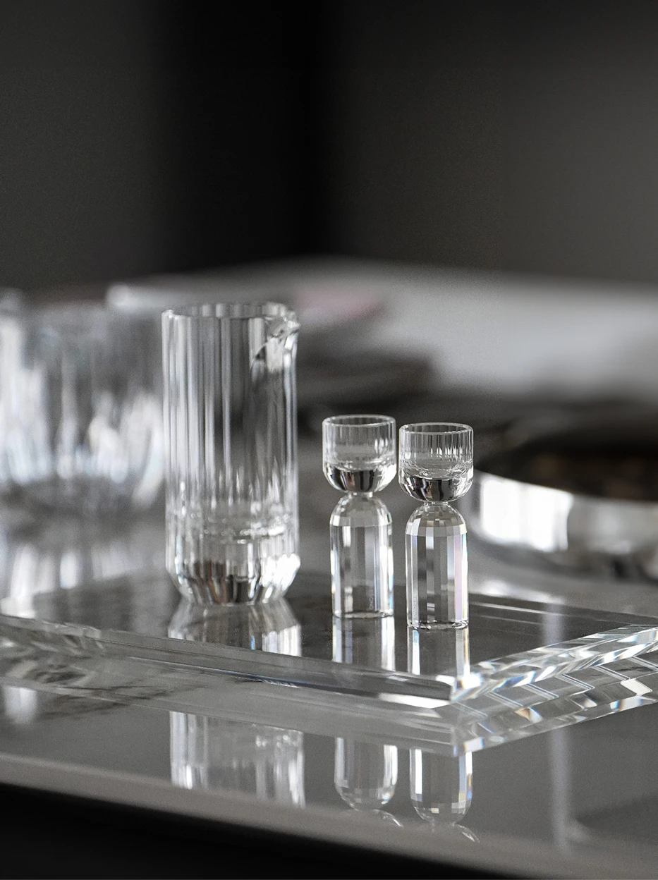 Minimal dark studio interior shot of full HAOYING crystal baijiu set laid on thick transparent crystal tray, reflective tabletop showing complete mirror reflection