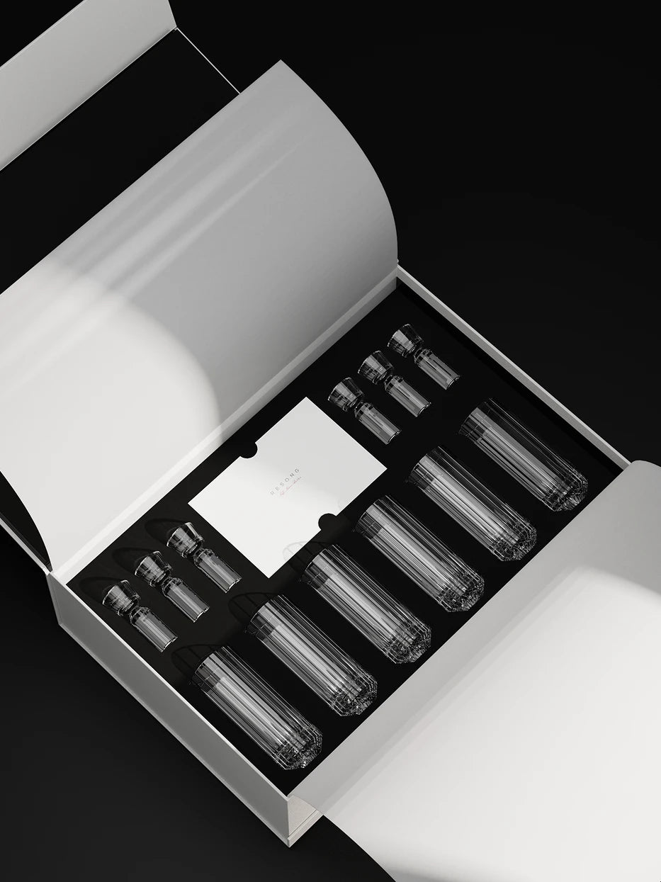 Luxury unboxing lifestyle shot of complete HUAZUN 6-glass 6-decanter crystal baijiu set, neatly embedded inside black flocking lining of original white gift box with brand card