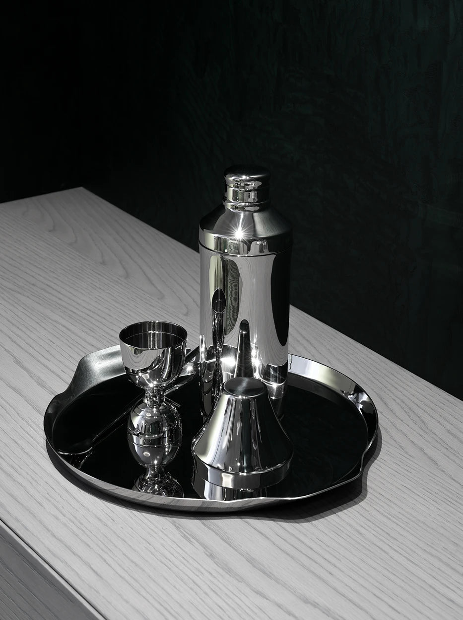 Dark tone close-up shot of full SHEDI bar tool set on irregular mirror metal tray against dark wood textured tabletop