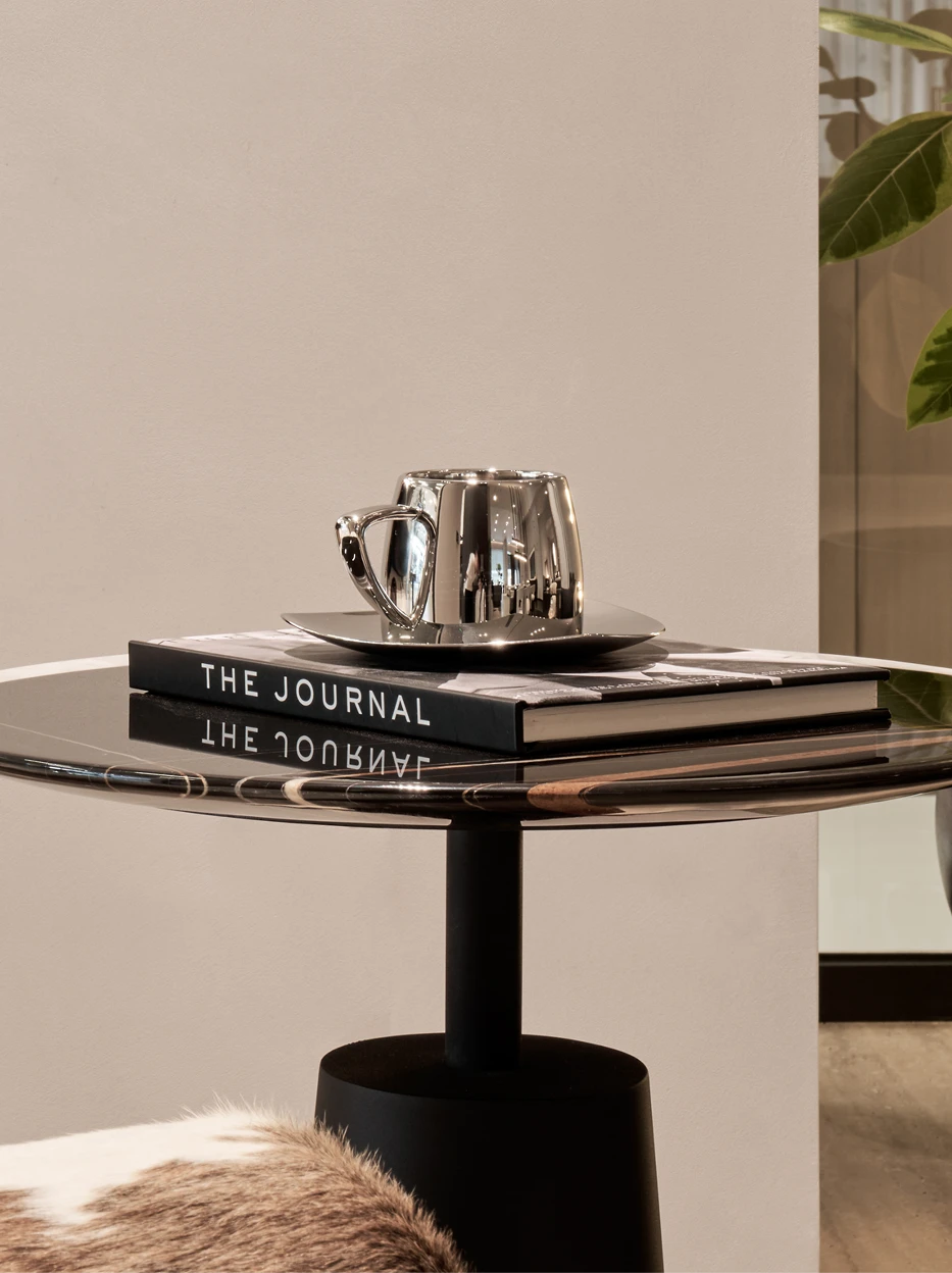 Home decor matching shot of SHEDI large double-wall cup set on marble round coffee table, paired with hardcover journal and green foliage beside plain cream wall