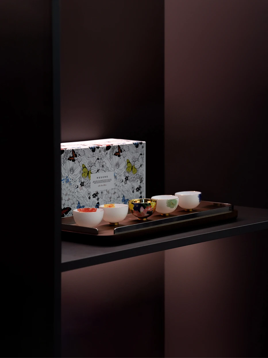 Premium gift display shot of full five-piece underglaze cup set on dark shelf, matched with butterfly printed flip gift box for holiday gift display