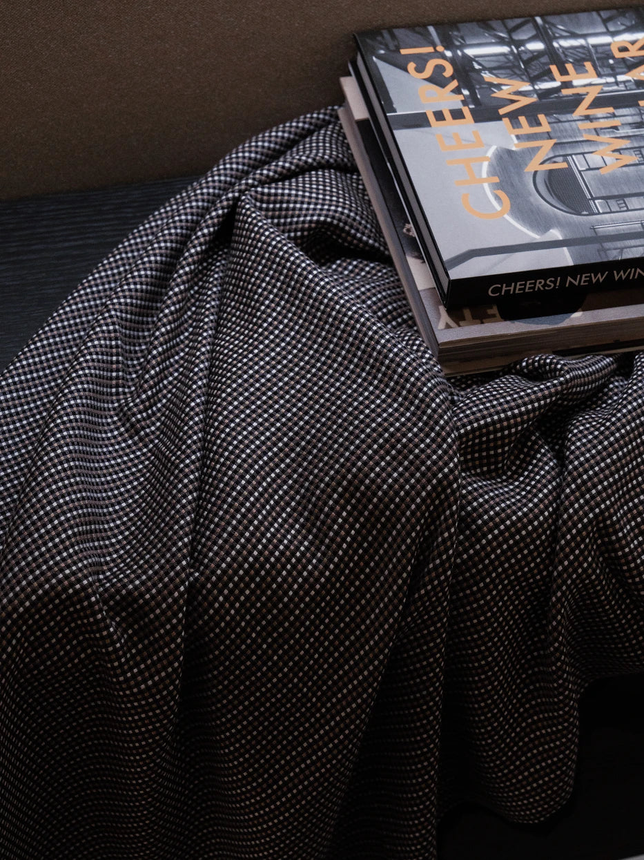 Large drape fold texture shot of LUODI wool viscose blend check throw blanket, showing dense tiny black-white-brown check woven texture and soft flowing drape detail, visible soft wool touch and silky smooth drape of viscose fiber, displays premium dual-fabric knit craft and delicate retro check tactile texture for home textile display