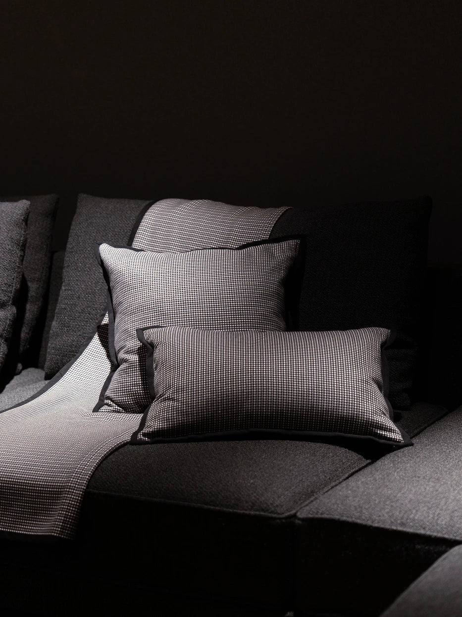Dark minimalist living room combo furnishing layout shot, LUODI square & lumbar tiny check cashmere cushions matched with same series throw blanket on dark fabric sofa, retro check texture creates premium soft contrast with dark furniture, rich visual layered decor for villa lounge, club reception, large flat living room, dark neutral interior styling