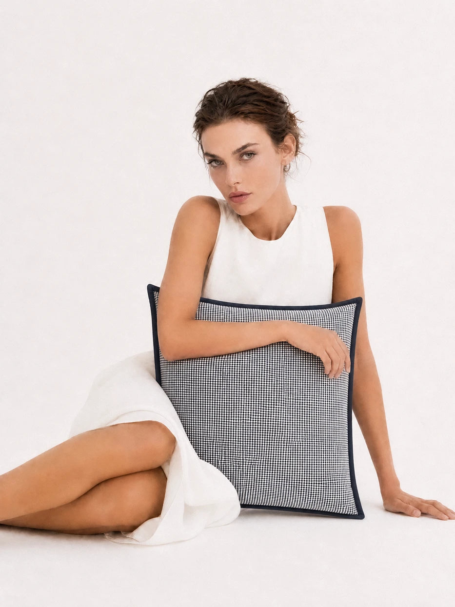 Minimalist full-body portrait shot of model holding LUODI retro check cashmere cushion, fully displays square 45cm cushion silhouette, full-width tiny check layout and black contrast edge design, dual function as decorative home sofa cushion and comfortable rest pillow for indoor daily use