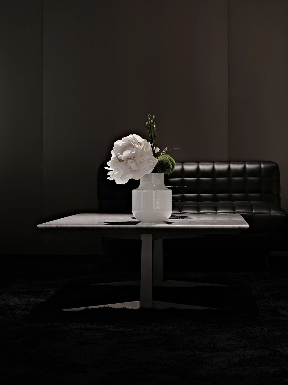 Dark minimalist artistic furnishing shot of minimalist vase B with single large white peony on dark gloss marble coffee table
