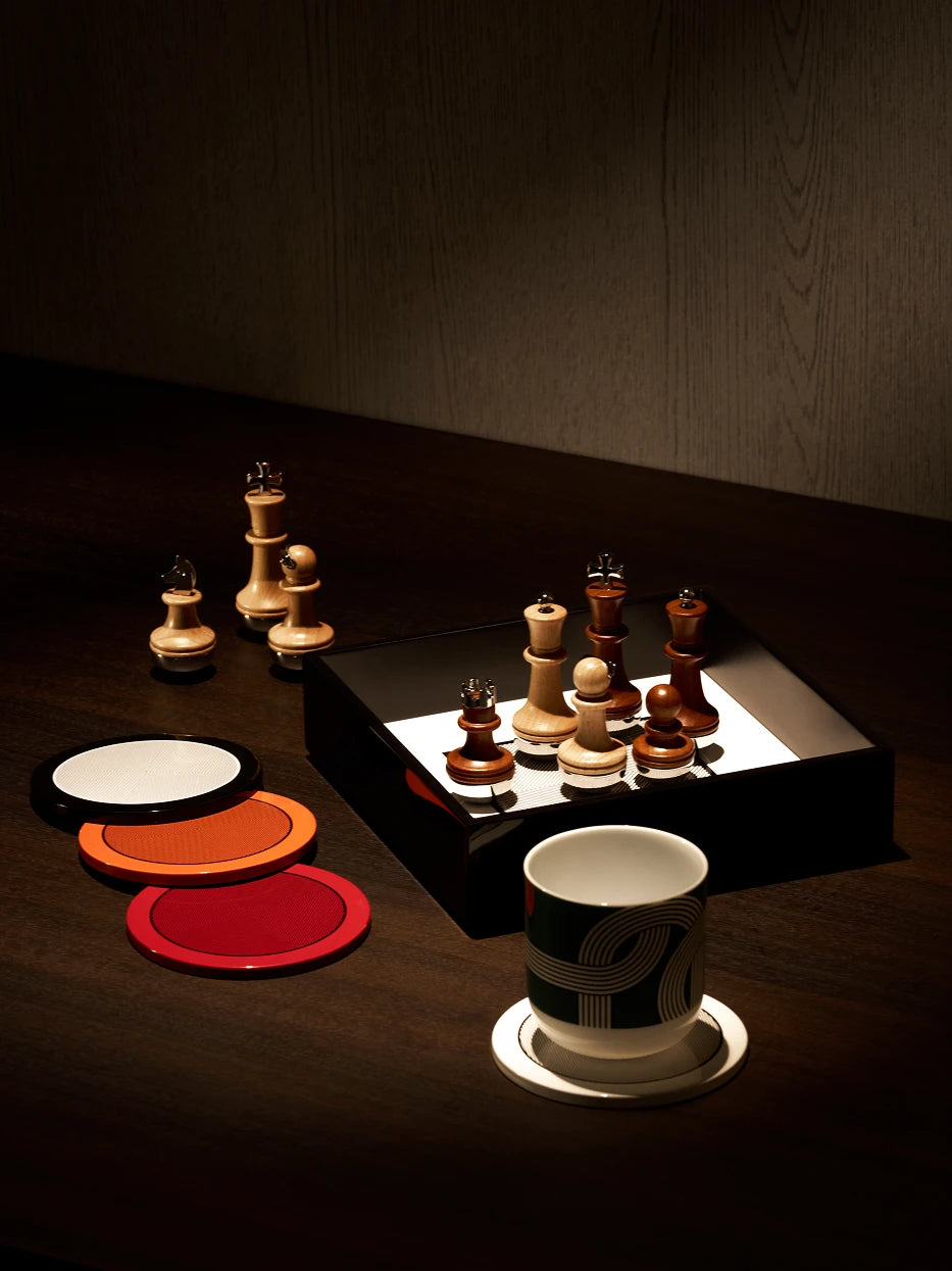 Luxury men's reception layout shot of red round coaster matched with multi-color coasters and leather chess box on dark solid wood table