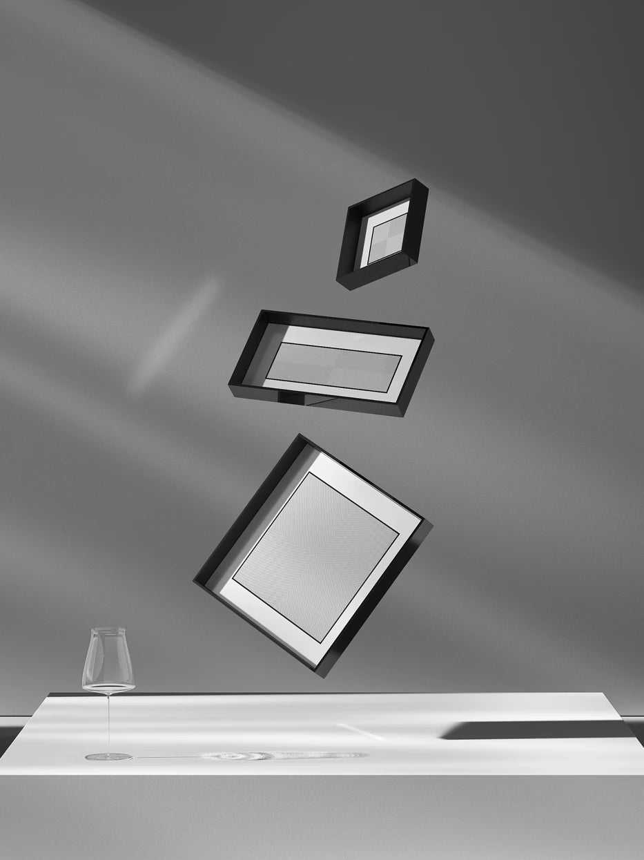 Art texture still life shot of full three-size square trays suspended in layers with crystal goblet against minimalist grey-white background