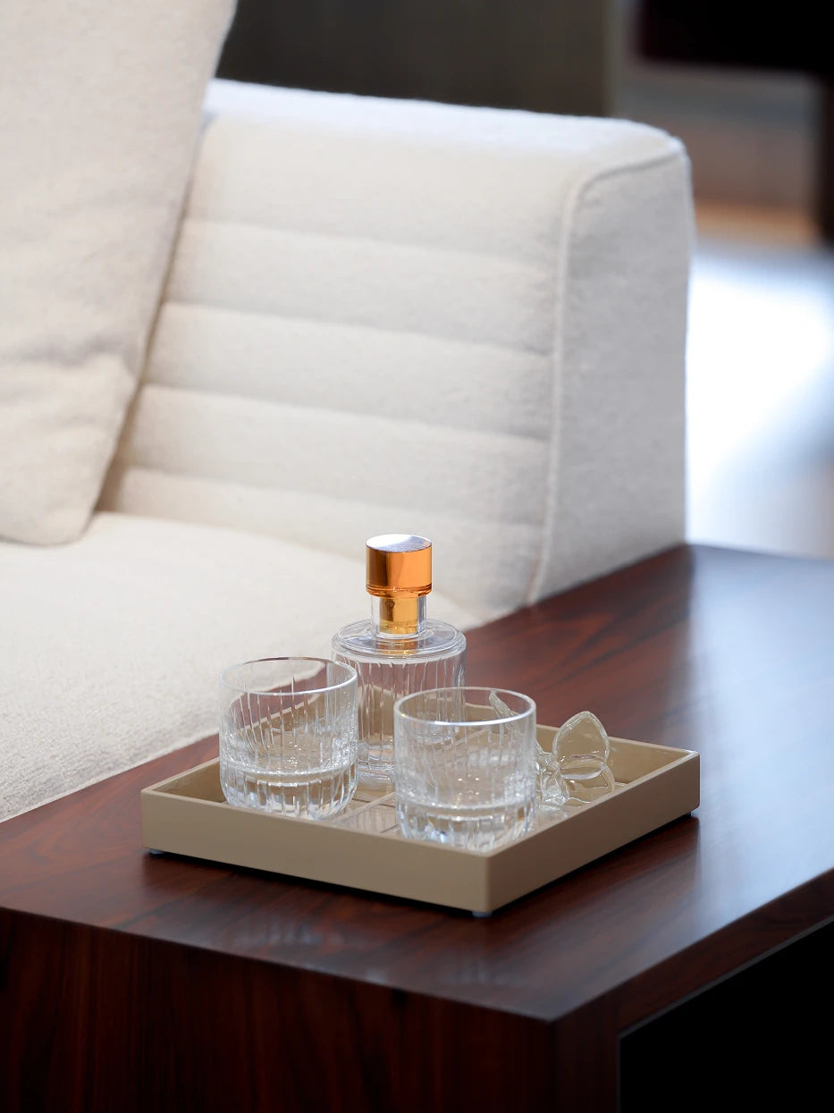 Cream style living furnishing shot of khaki four-grid tray on light walnut coffee table matched with ribbed glass cups & aromatherapy ornaments
