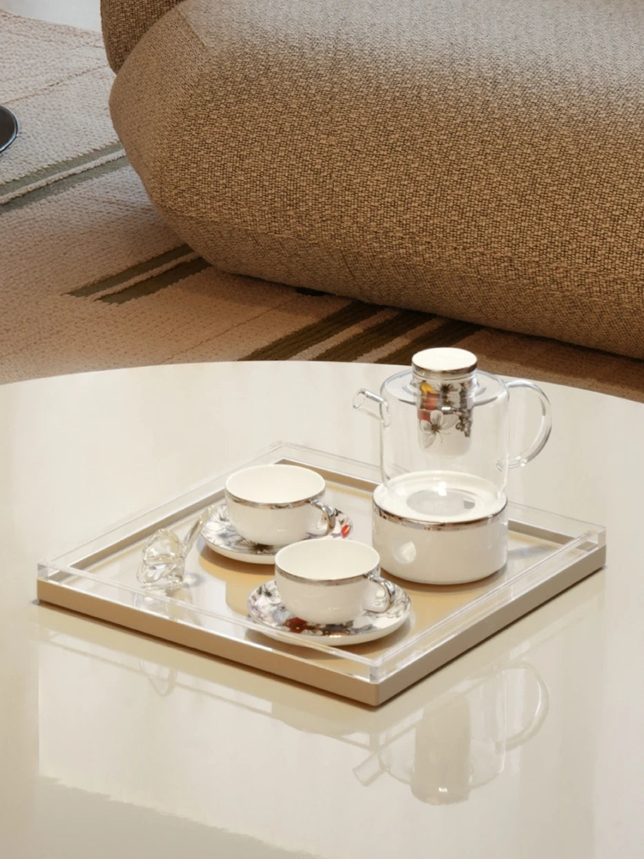 Soft minimalist living furnishing shot of khaki square tray on white round slate tea table matched with white porcelain tea set