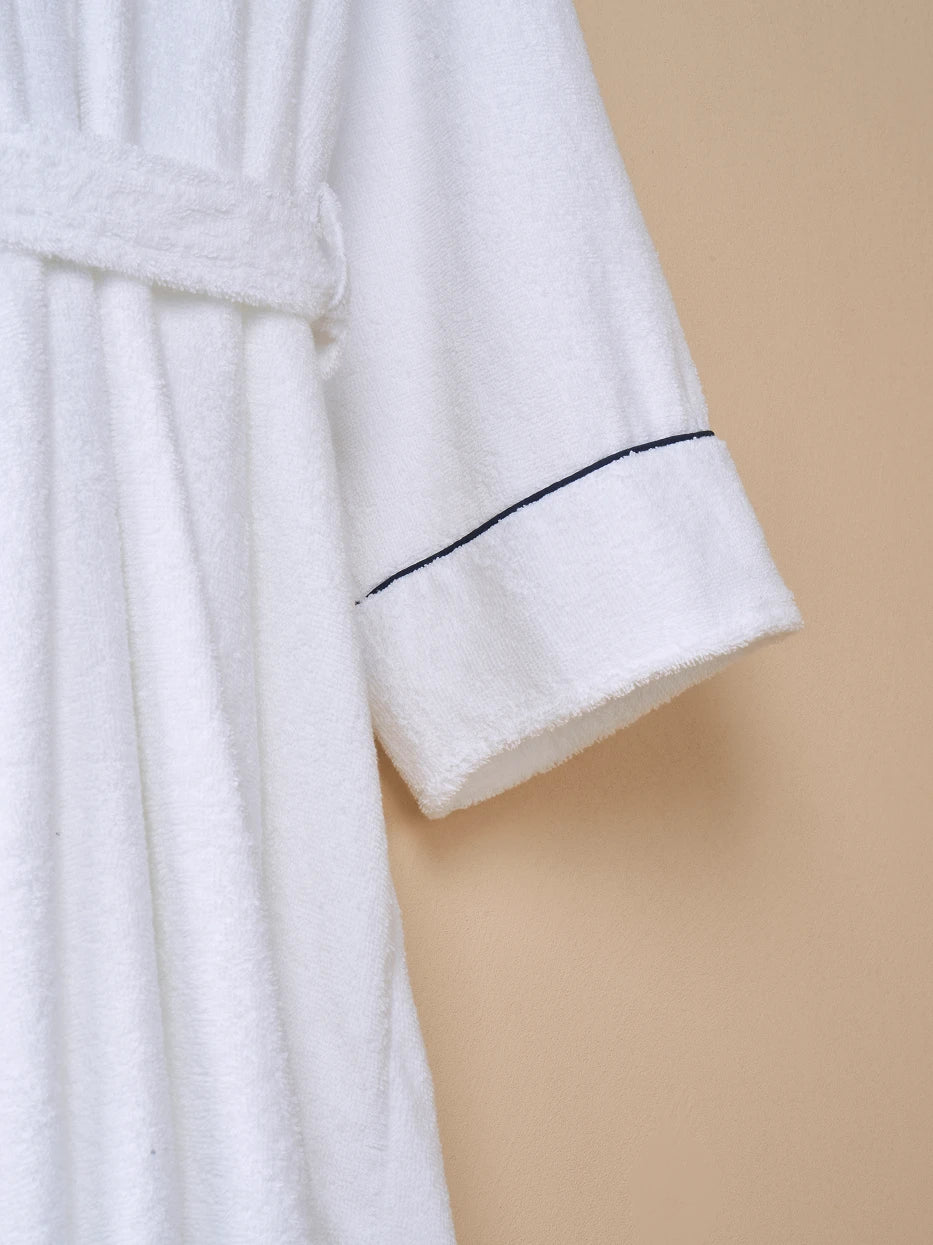 Extreme macro texture close-up of 100% white cotton terry fabric of R Collection bathrobe, thick full loop terry knit grain, clearly shows delicate soft cotton touch and fast water absorption performance, densely woven fabric resistant to lint shedding and yellowing after repeated washes