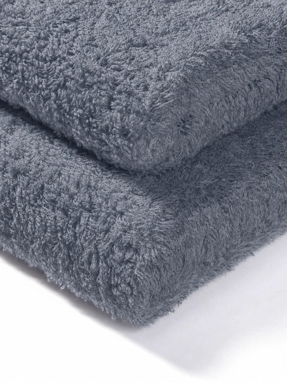 Extreme macro texture close-up of 100% cotton terry of R Collection grey face towel, full three-dimensional loop terry grain, clearly shows thick 200g heavyweight texture, soft skin-friendly cotton and fast water absorption, dense weave resistant to lint shedding and fading after repeated washes