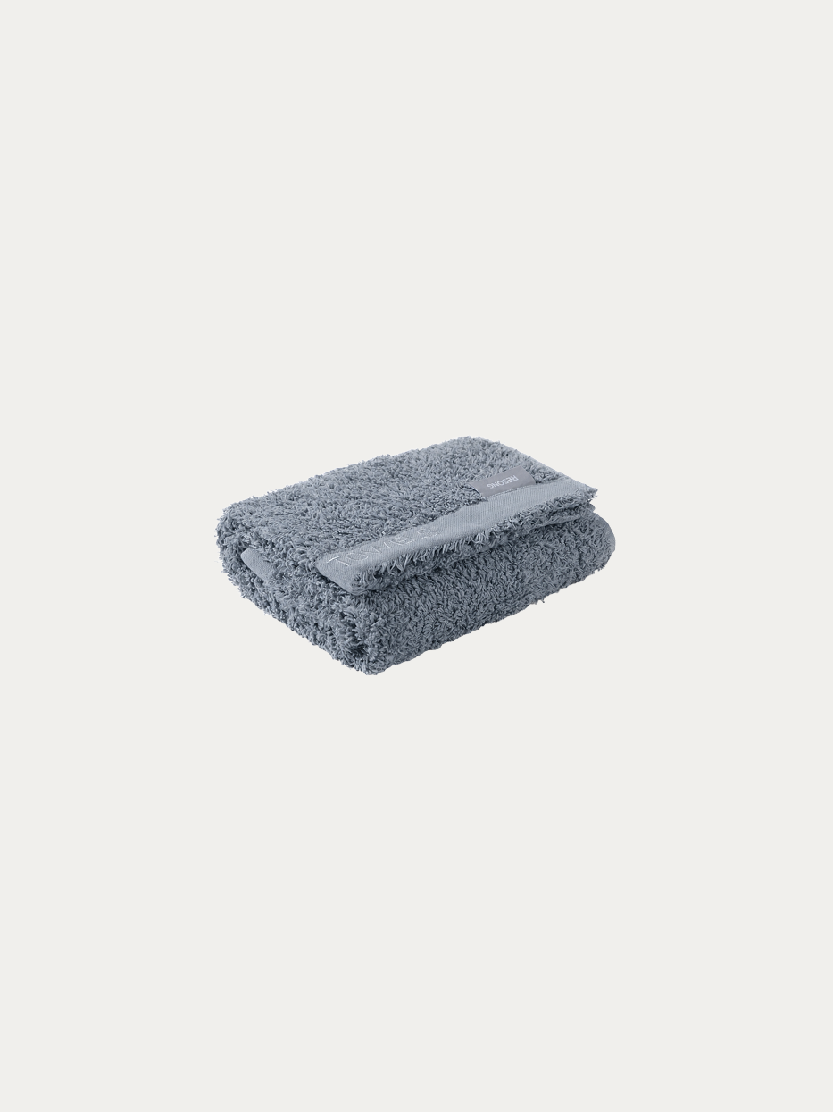 Official folded product shot of R Collection grey cotton face towel on pure off-white background, oversized 750×410mm, 200g heavyweight thick terry, woven band embroidered with TOWELS logo, water-absorbent facial towel for hotel & gift box matching