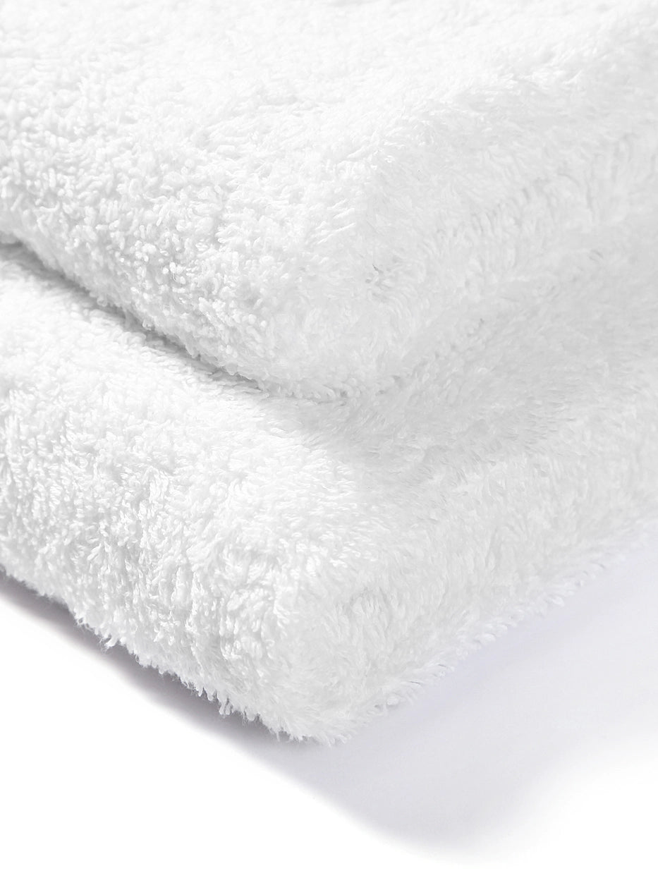 Extreme macro texture close-up of 100% cotton terry of R Collection white face towel, full three-dimensional loop terry grain, clearly shows thick 195g heavyweight texture, soft skin-friendly cotton and fast water absorption, dense weave resistant to lint shedding