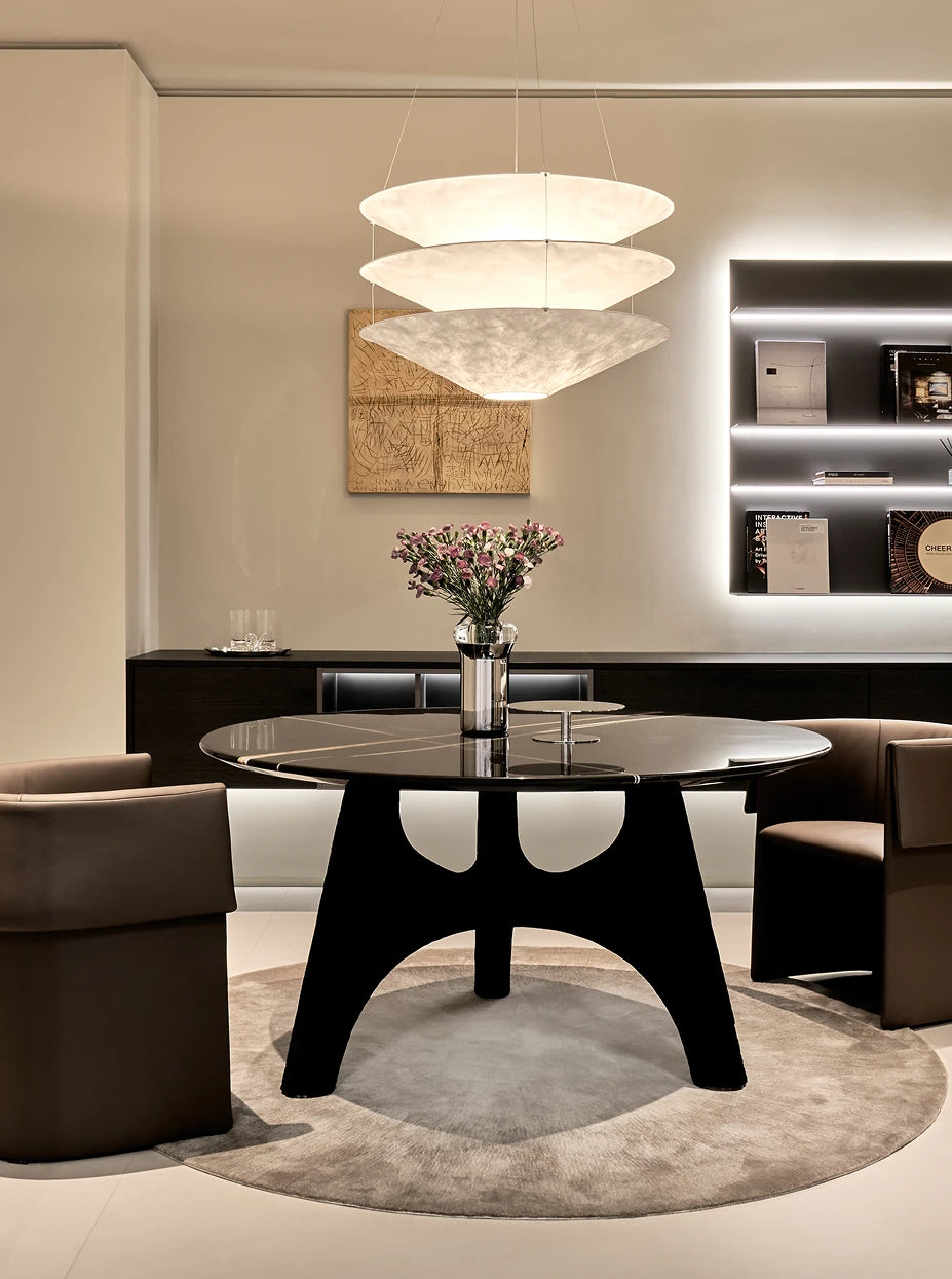 Monochrome minimalist dining furnishing shot of SHEDI double-wall vase with light pink bouquet on black gloss marble round dining table