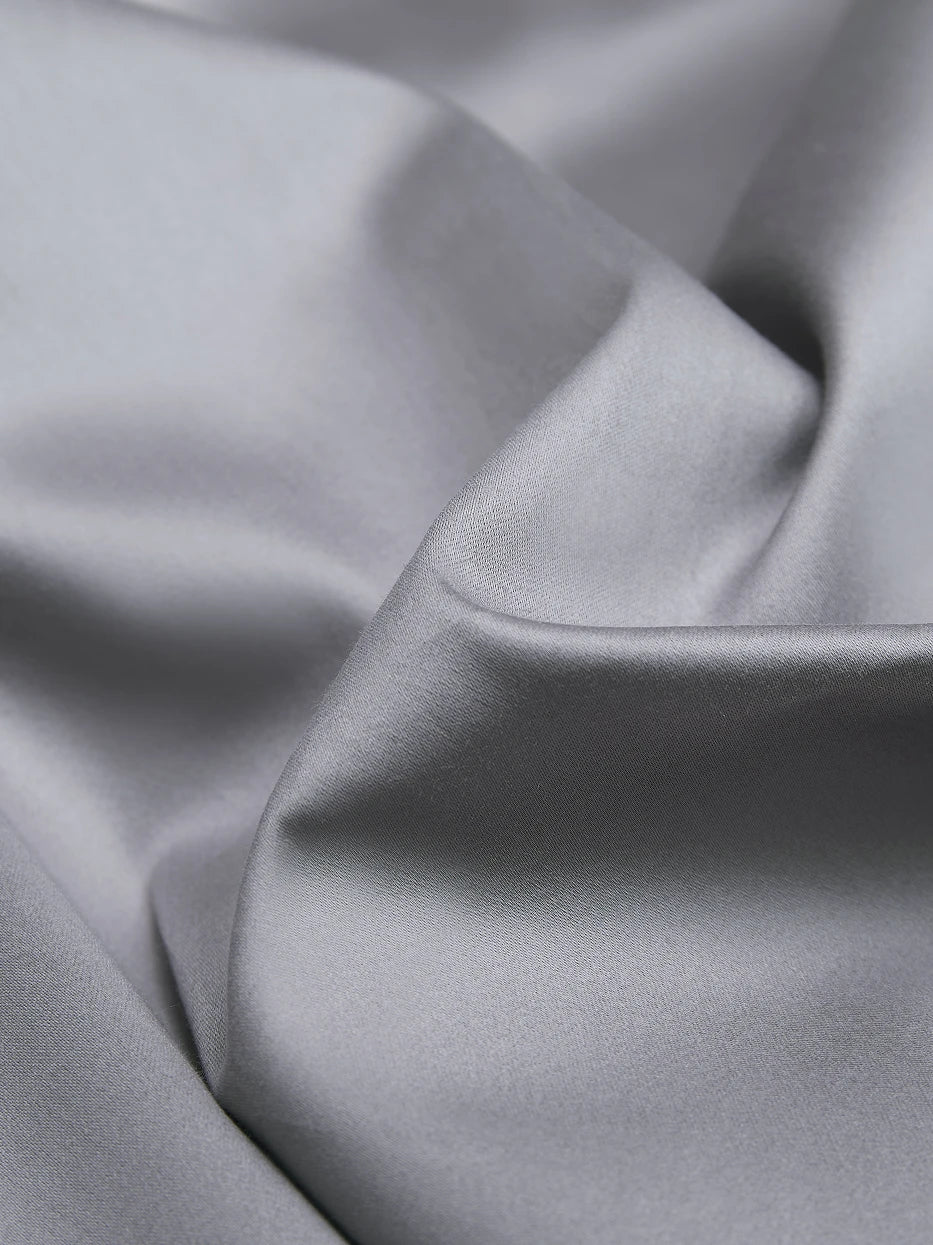 Soft natural light close-up shot of SHUMIAN gray cotton fabric, showing smooth matte satin luster, tight high-density 480TC weaving